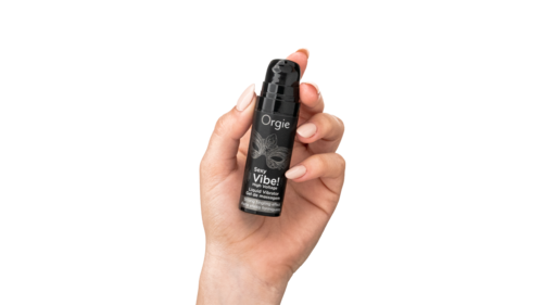 Eine Hand hält eine kleine schwarze Sprayflasche mit dem Etikett Orgie Vibe!
