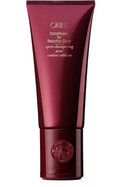 Eine lange, pinkrote Tube mit Oribe Conditioner, glänzendes Design und Logo auf dem Deckel.