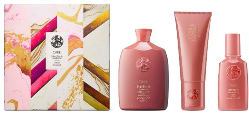 The image shows a gift box and three pink skincare products in bottles and tubes.