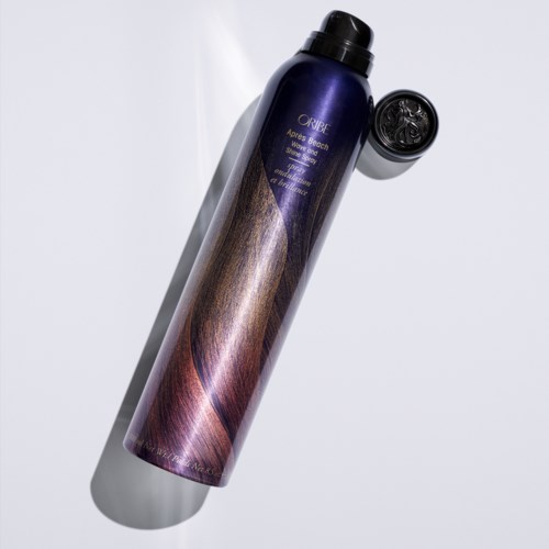 Een lange, paarse en bruine shampoo fles met zwarte dop, geplaatst op een witte ondergrond met schaduw.