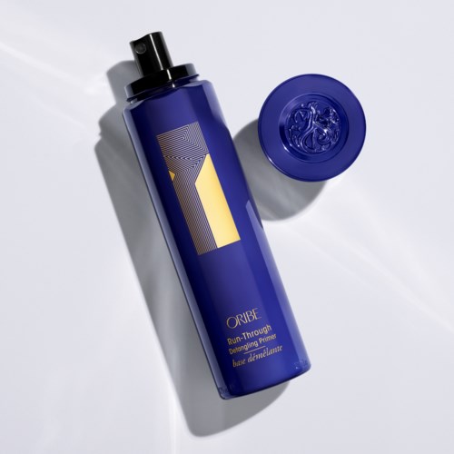 Eine blaue Flasche mit schwarzem Verschluss und passendem blauen Deckel, beschriftet 'Oribe', steht auf weißem Hintergrund.