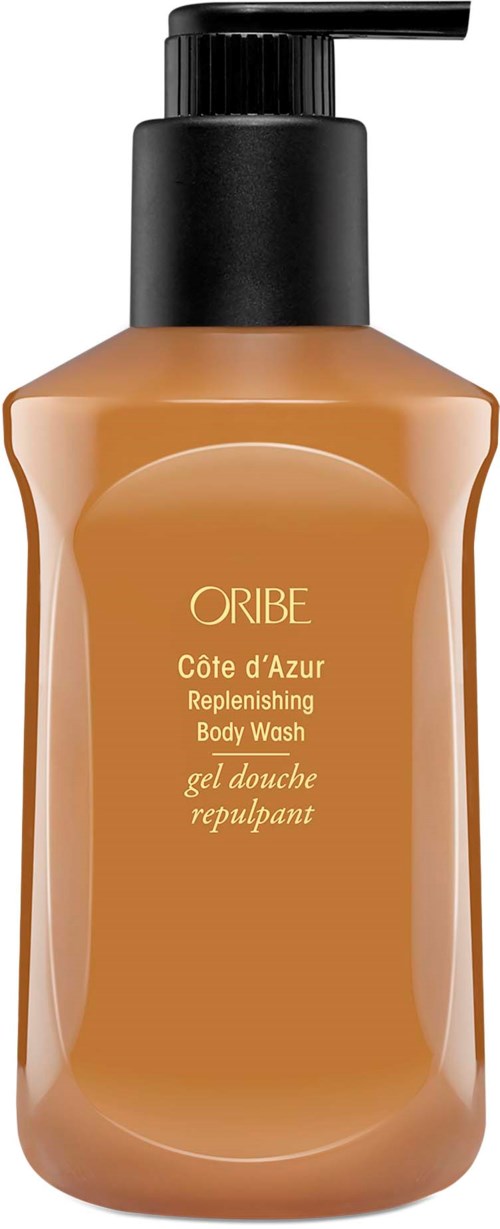 Eine beige Körperwaschflasche mit schwarzem Pumpdeckel, beschriftet als Oribe Côte d'Azur Replenishing Body Wash.