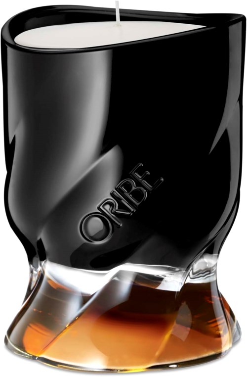 En svart och klar ljushållare med en tänd vit ljus, märkt 'ORIBE.'