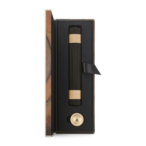 Ein schwarzer zylindrischer Gegenstand in einer Box, gesichert mit Bändern, mit einem kleinen Zahnrad.