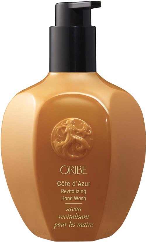 Beige Flasche mit schwarzem Pumpkopf, beschriftet Oribe Côte d'Azur Handwäsche. Mit Löwenlogo vorne.