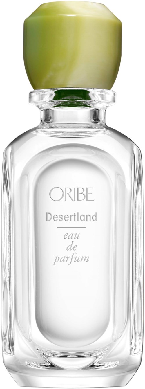 A clear glass perfume bottle with a green cap labeled 'Oribe Desertland eau de parfum.'