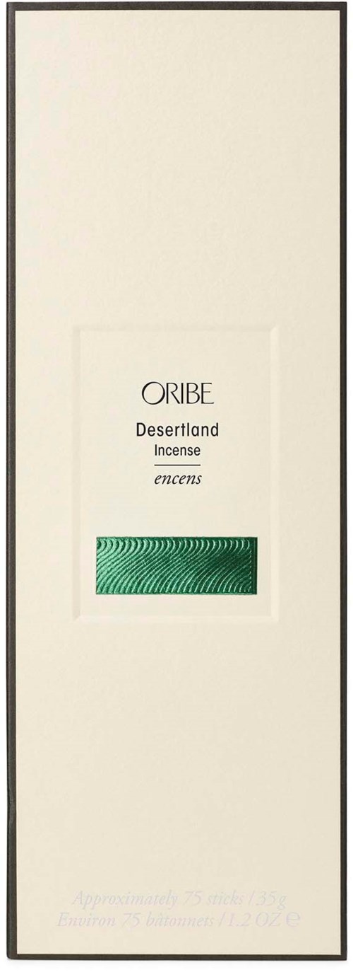 Eine lange weiße Box mit schwarzem Rand, mit einem kleinen grün gemusterten Rechteck und Text über Oribe Wüstendüfte.