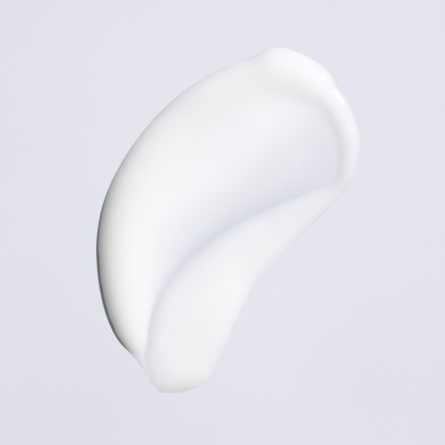 Weiße Creme oder Lotion auf einfachem grauem Hintergrund. Glatte und glänzende Oberfläche wirkt weich und frisch.