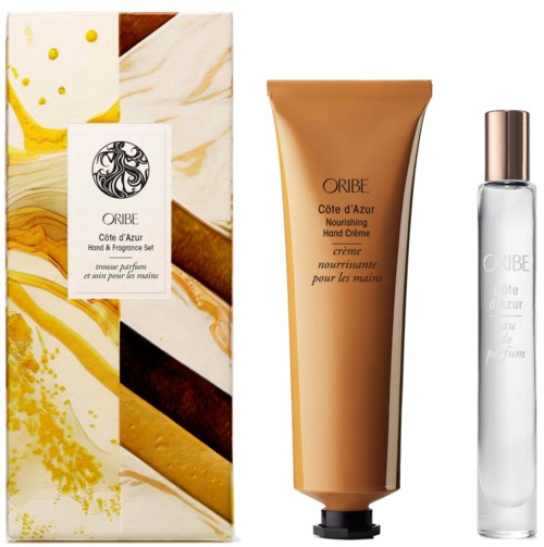 Een geschenkset met vochtinbrengende handcrème, parfum en een decoratieve doos met gele en bruine abstracte ontwerpen.