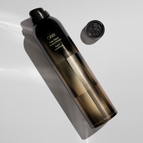 Eine schwarze Flasche mit gold- und weißem Text und passendem Deckel, liegend auf einer weißen Oberfläche. Es ist ein Produktbehälter.
