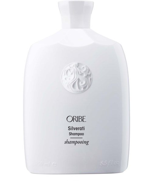 Een witte shampoo fles met ronde top, gegraveerd logo en zwarte tekst "ORIBE Silverati Shampoo."