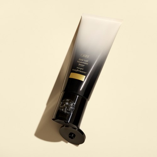 Ein Tube mit ORIBE Gold Lust pflegende Haarmaske auf hellem Hintergrund.