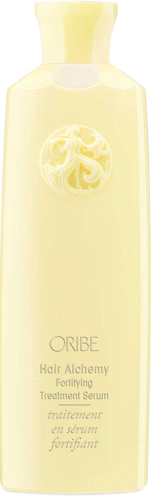 A tall, light yellow bottle labeled 'Oribe Hair Alchemy Fortifying Treatment Serum.'