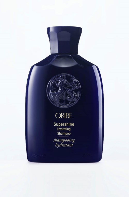 Eine dunkelblaue Flasche mit Oribe Supershine Hydrating Shampoo und einem silbernen Emblem.