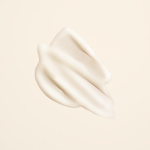 Ein Klecks weiße Creme oder Lotion vor einfachem Hintergrund.