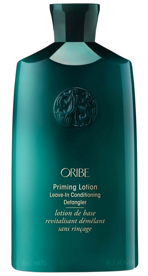 En blågrønn flaske merket ORIBE Priming Lotion, Leave-In Condition, Detangler, i et elegant, moderne design.