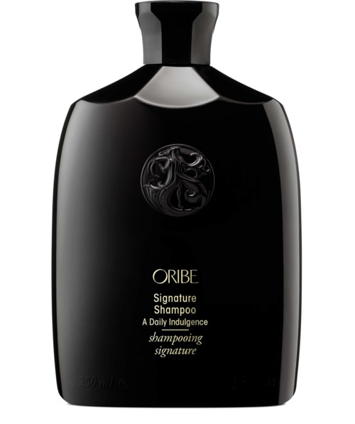 Schwarze Shampooflasche mit gold- und schwarzem Etikett, mit elegantem Logo und den Worten 'ORIBE Signature Shampoo' und 'shampooing signature.'