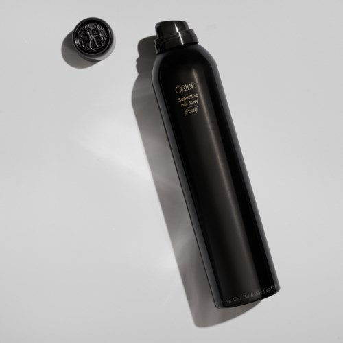 Eine elegante, schwarze, lange Flasche mit einem Deckel in der Nähe, beschriftet "Oribe" und "Superfine".