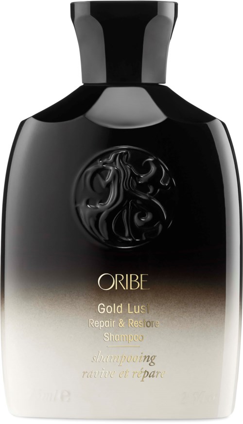 Eine schwarze und weiße Shampoo-Flasche mit Goldschrift, gekennzeichnet als ORIBE Gold Lust Repair & Restore Shampoo.