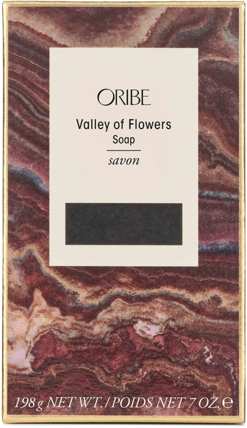 Eine Seife in einer eleganten Schachtel mit marmorierten braunen und rosa Hintergründen, beschriftet 'Valley of Flowers' von Oribe.