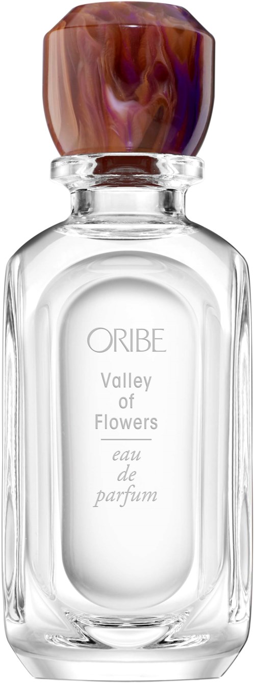 A clear perfume bottle with a colorful, marbled top and a simple label that says "Valley of Flowers."