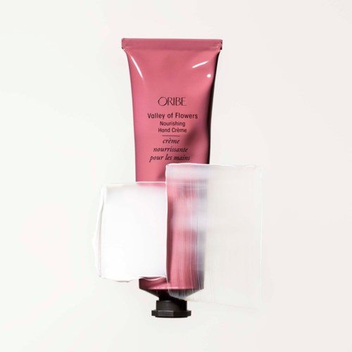 Pinke Handcremetube mit klarem Plastikschutz, beschriftet 'Valley of Flowers' von Oribe.