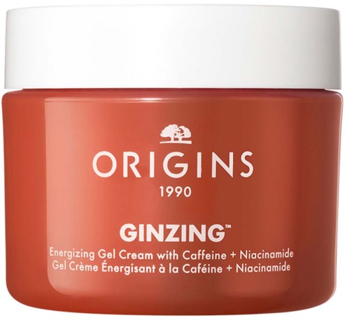 Ein kleiner Behälter mit orangegeliger Creme und weißem Deckel, markiert ORIGINS GINZING, mit Teebaum-Logo und Beschreibung.