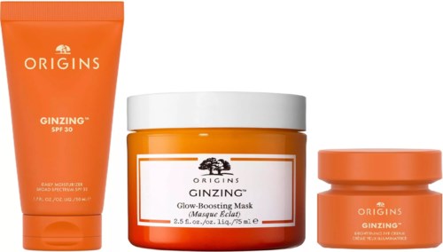 Drei orange Hautpflegeprodukte in Gläsern und eine Tube von Origins, mit Text zu SPF 30 und Glow-Boosting.