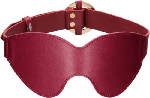 Rote Schlafmaske mit einem Band und goldener Schnalle, bedeckt die Augen zum Ausruhen oder Entspannen.