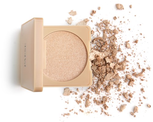 A beige compact with pressed powder, some powder scattered around on a white surface.