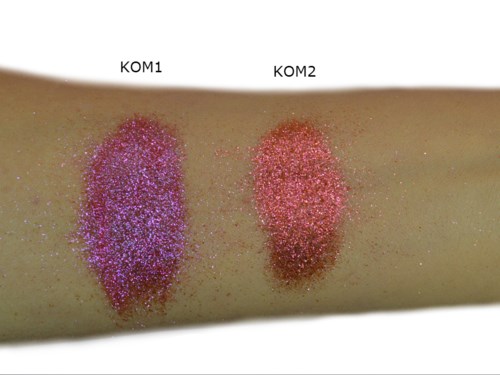 Twee glittermonsters met labels KOM1 en KOM2 op huid, paars en roze, met wat verspreid glitter eromheen.