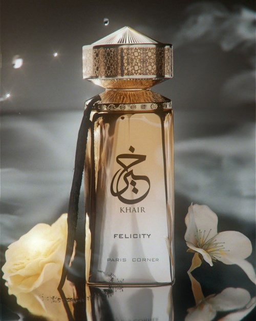 A perfume bottle with gold accents, surrounded by flowers and a dark, smoky background.