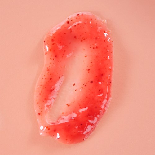 Ein pinkfarbenes, glänzendes, unregelmäßig geformtes Objekt mit roten Flecken und Flüssigkeit.