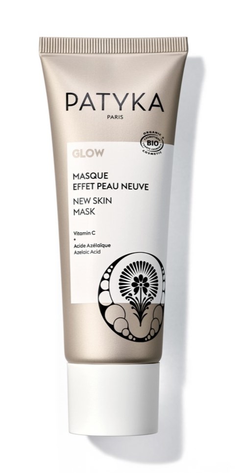 Een tube Patyka Glow gezichtsmaske met wit en goud ontwerp, met productgegevens en een zwart bloemlogo.