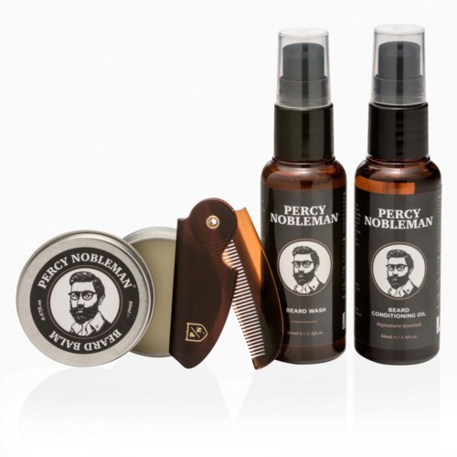 A grooming set with beard wash, conditioning oil, a small tin, and a comb. All items are branded Percy Nobleman.