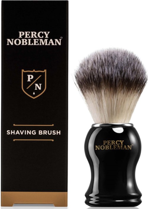 A black shaving brush with a rounded handle, gold lettering, and thick white and gray bristles next to a black box.