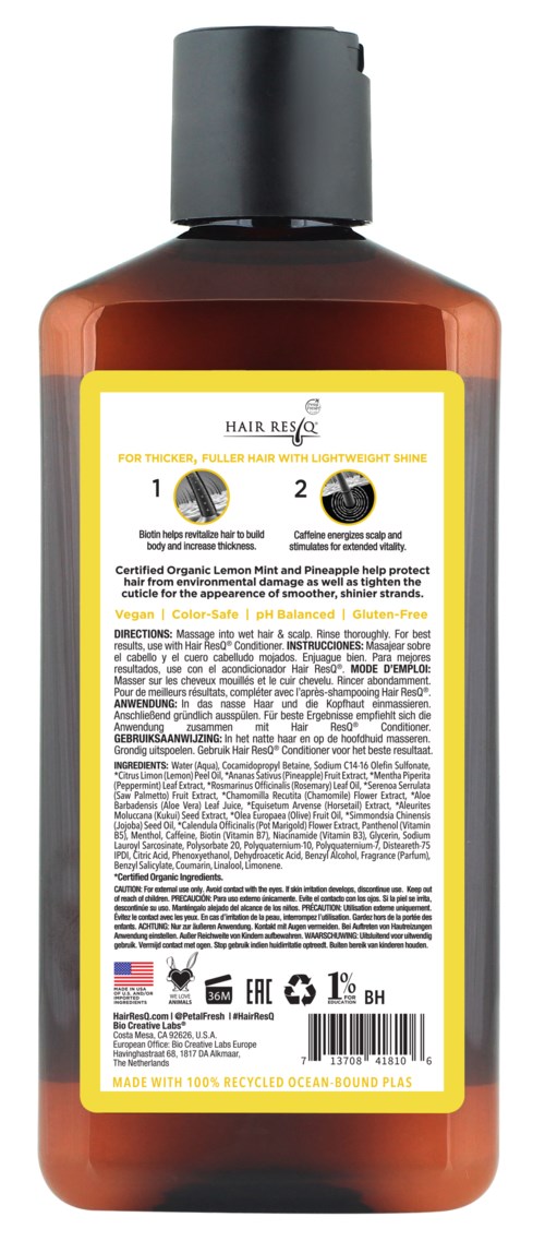 A brown bottle with a black cap, yellow and white label, contains hair care product.