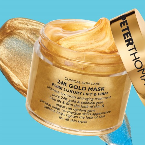 A jar of Peter Thorne's gold face mask with a gold spatula and blue background.