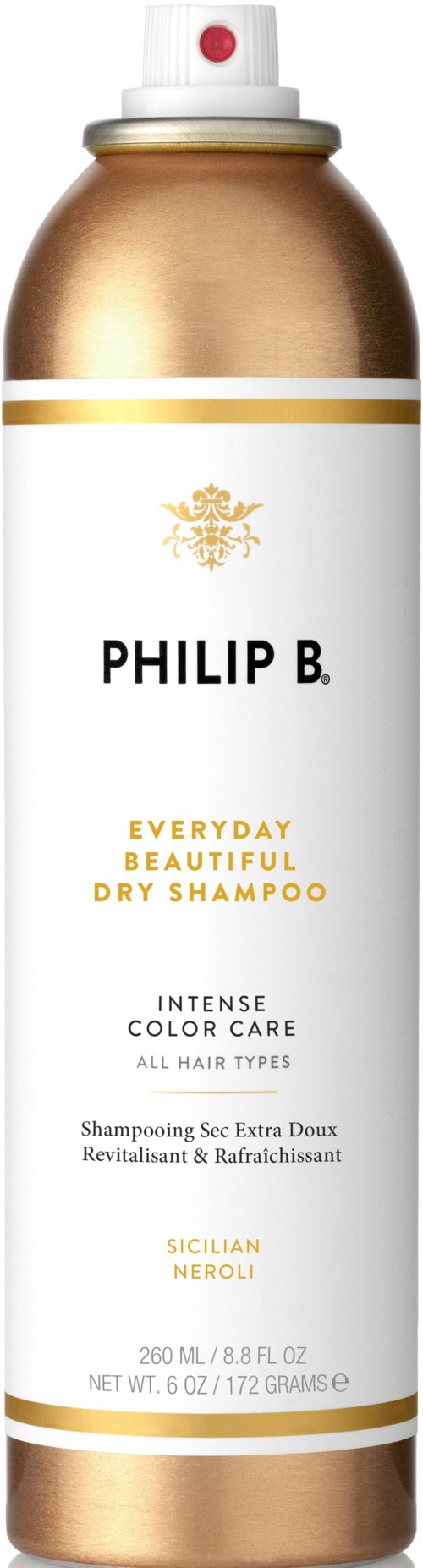 Een lange spuitbus met wit en goud etiket, tekst over droogshampoo voor alle haartypes.