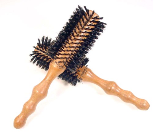 Two wooden hairbrushes with black bristles crossed each other.