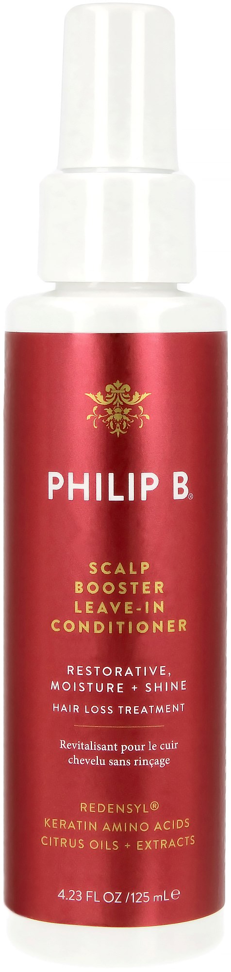 Eine rote Flasche mit der Aufschrift 'Philip B.' enthält eine Leave-in-Haarpflege, hergestellt mit Keratin und Zitrusölen.