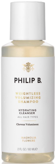 Eine weiße Flasche mit weißem Deckel, gekennzeichnet mit Philip B. Volumizing Shampoo für alle Haartypen, mit Magnolia-Blumen Duft.