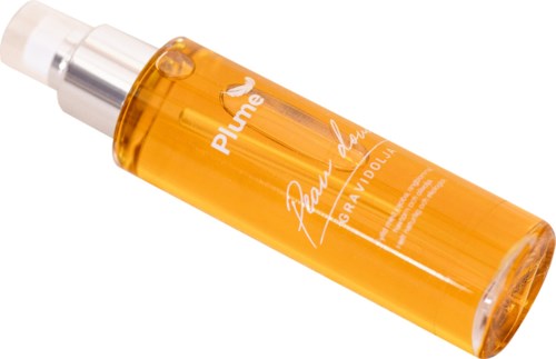 Ein gelb-orangefarbiger Sprühflasche mit weißem Text, liegt schräg.