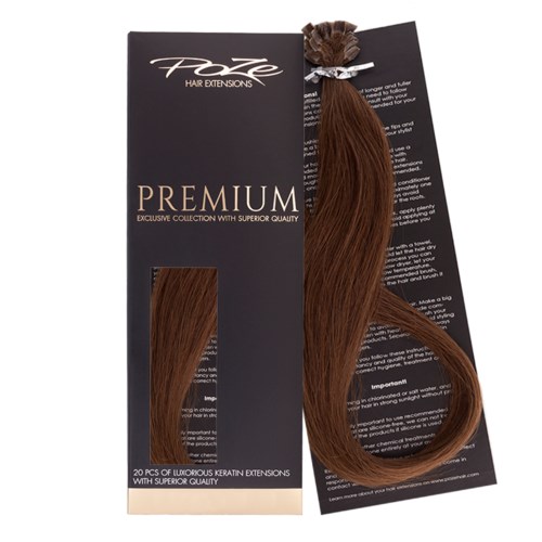 Een haarverlengingsverpakking bevat een bruine haarverlenging gebonden met een wit lint. De verpakking is zwart met tekst.