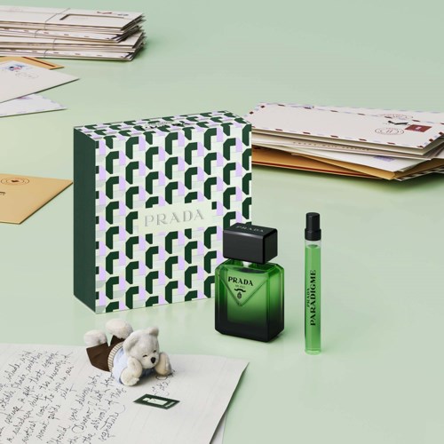 Prada parfymflaska med grönt flytande, svart lock, och ett matchande grönt parfymprov. Box med grön och vit geometrisk mönster.