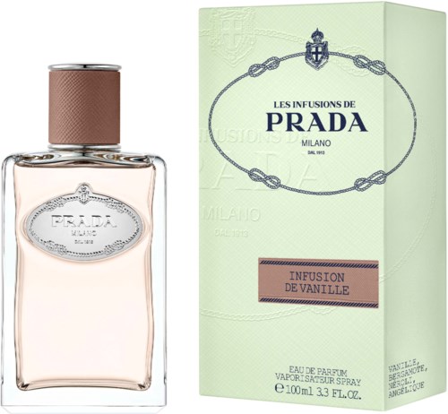 Een Prada-parfumbidon met lichtroze vloeistof en een groene doos met blauwe en roze tekst, vanillegeur.