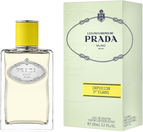 Een Prada-parfumboteltje met gele dop en lichte vloeistof, naast een lichtgroene doos met merk- en productgegevens.