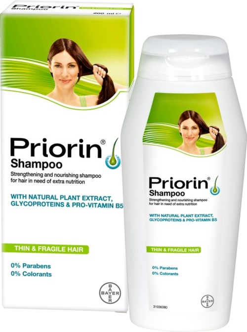 Nainen pitää pitkää hiusta, shampoo-pakkaus taustalla, värit valkoinen ja vihreä.