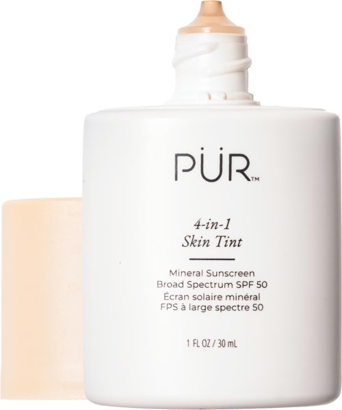 Valkoinen pullo pumppupullolla, merkki 'PUR 4-in-1 Skin Tint', sisältää mineraalisen SPF 50 aurinkovoiteen.