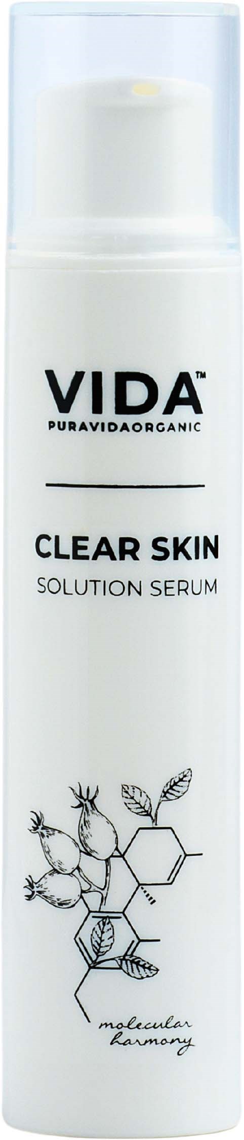 Een witte fles met zwarte tekst, getiteld VIDA Clear Skin Solution Serum, met een blad en honingraatontwerp onderaan.
